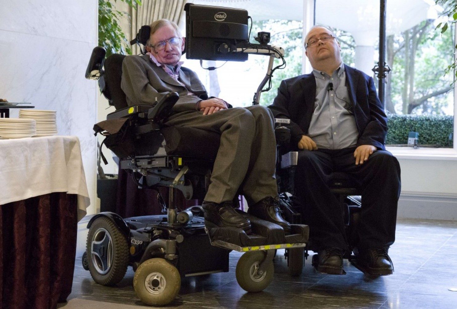 Stephen Hawking and Pete Denman side by side in their power wheelchairs at the London launch of ACAT in December 2014.